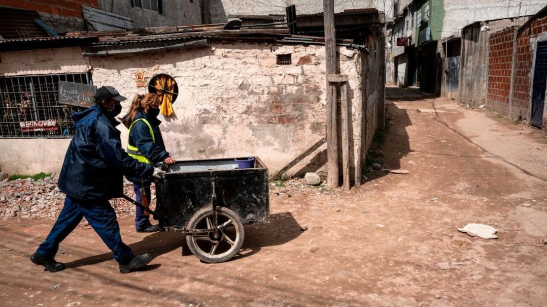 Integrantes de una organización social utilizan una carretilla para distribuir tanques de gasolina a personas duramente afectadas por la crisis económica, en la Villa 21-24 de Buenos Aires el 29 de septiembre de 2020