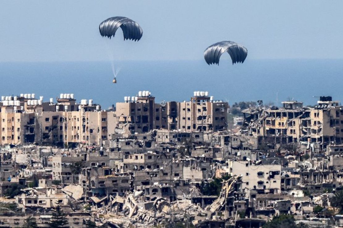 Esta imagen tomada desde la frontera sur de Israel conel enclave de Gaza muestra paracaídas de ayuda humanitaria cayendo sobre el territorio palestino asediado a finales de marzo de 2024.