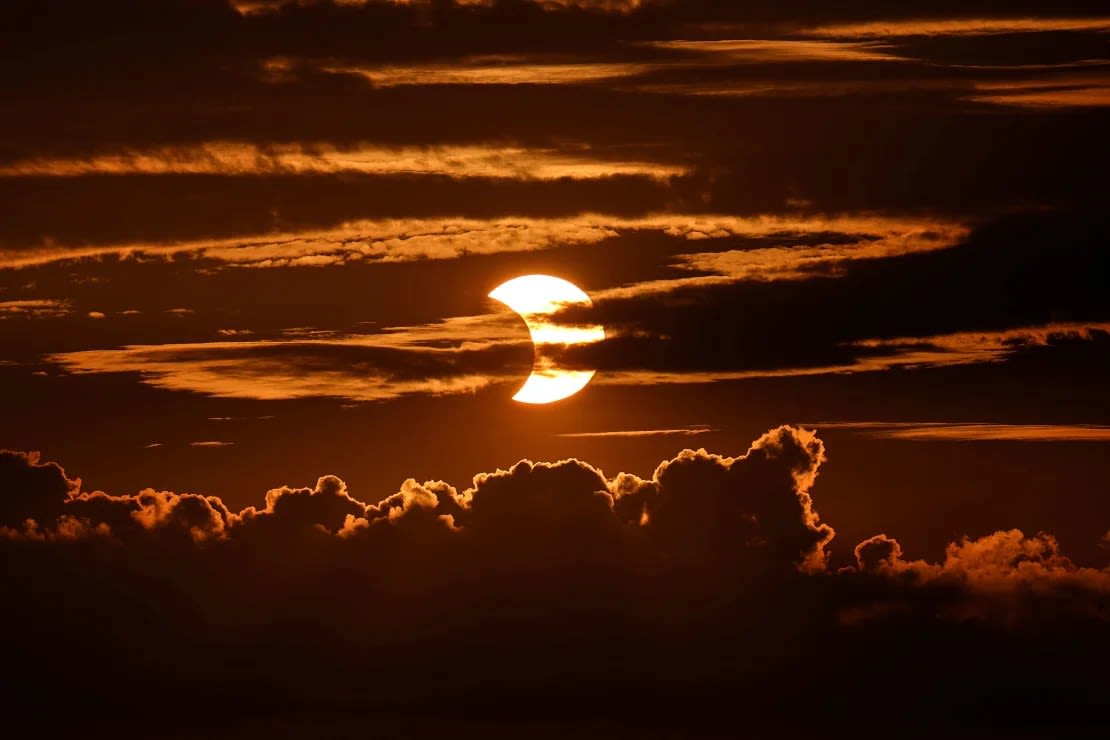 Se ven nubes de alto nivel en la parte superior de la imagen mientras se desarrolla un eclipse solar parcial detrás de las nubes, el jueves 10 de junio de 2021, en (Foto: Arbutus, Maryland. Julio Cortez/AP).