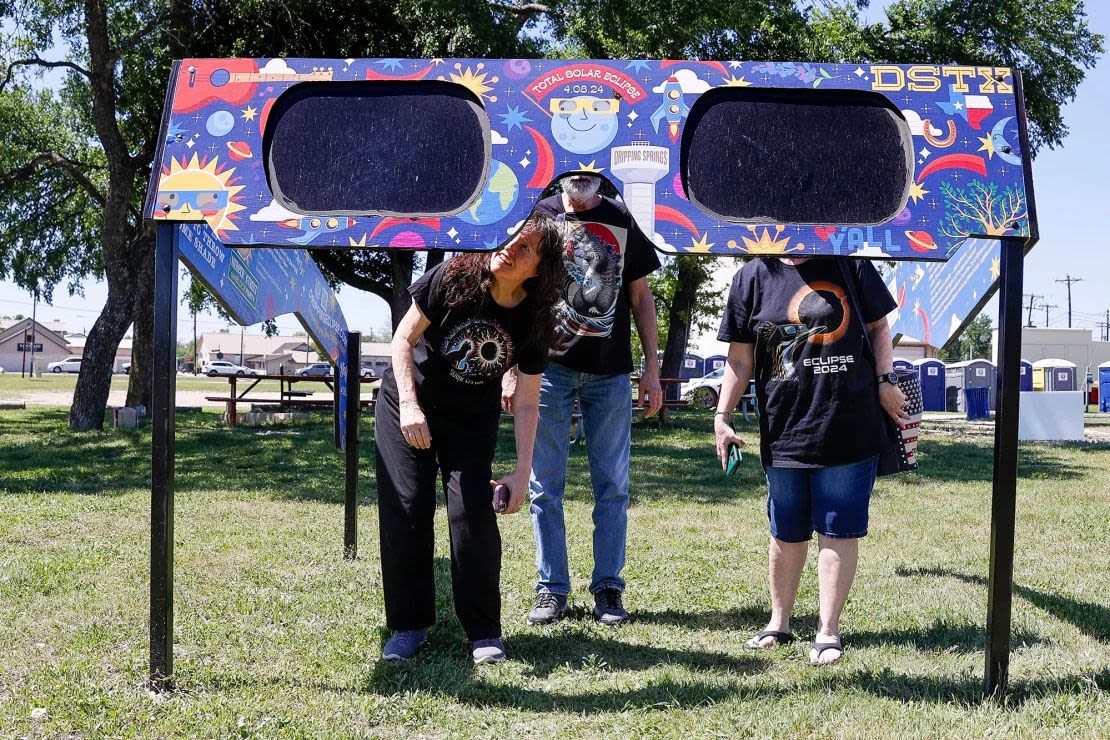 Una familia mira a través de unas gafas gigantes de eclipse solar en el Veterans Memorial Park de Dripping Springs, Texas, el 4 de abril de 2024. Adam Davis/EPA-EFE/Shutterstock