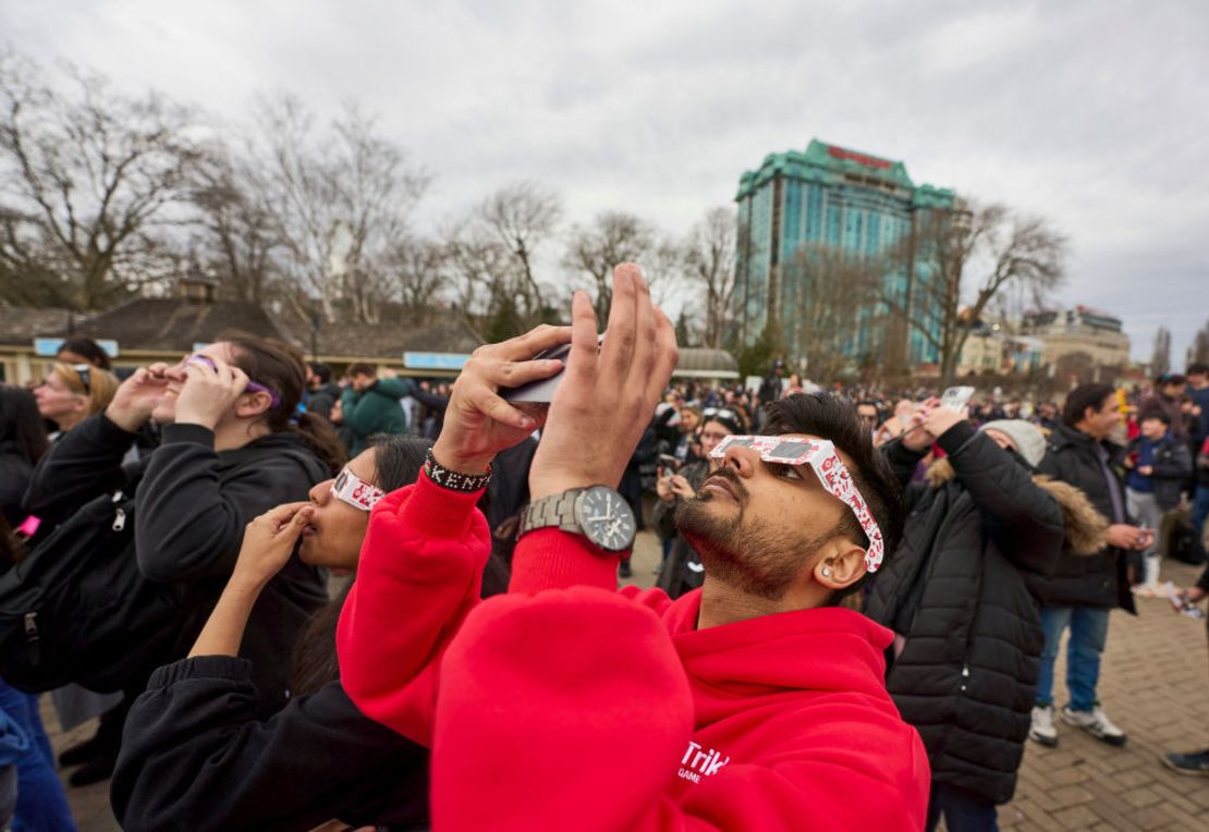 Varias personas miran al cielo mientras se preparan para el eclipse total que pasará por la región a última hora del día, en las cataratas del Niágara, Ontario, Canadá, el 8 de abril de 2024.