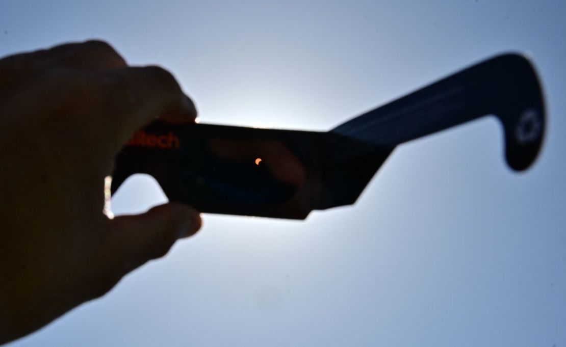 Vista del eclipse solar a través de los lentes protectores que se repartieron a las personas que se reunieron para el evento astronómico en Caltech, en Pasadena, California, el 8 de abril de 2024.