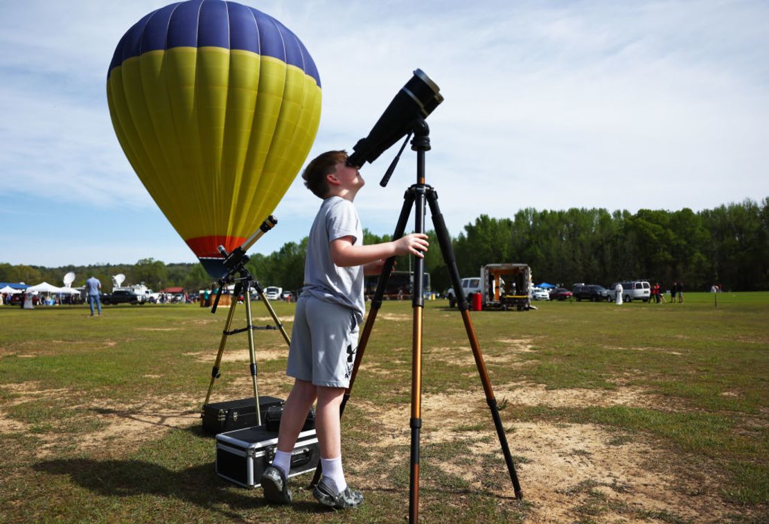 Un joven observa el sol con binoculares en el festival Total Eclipse of the Heart el 8 de abril de 2024 en Russellville, Arkansas.