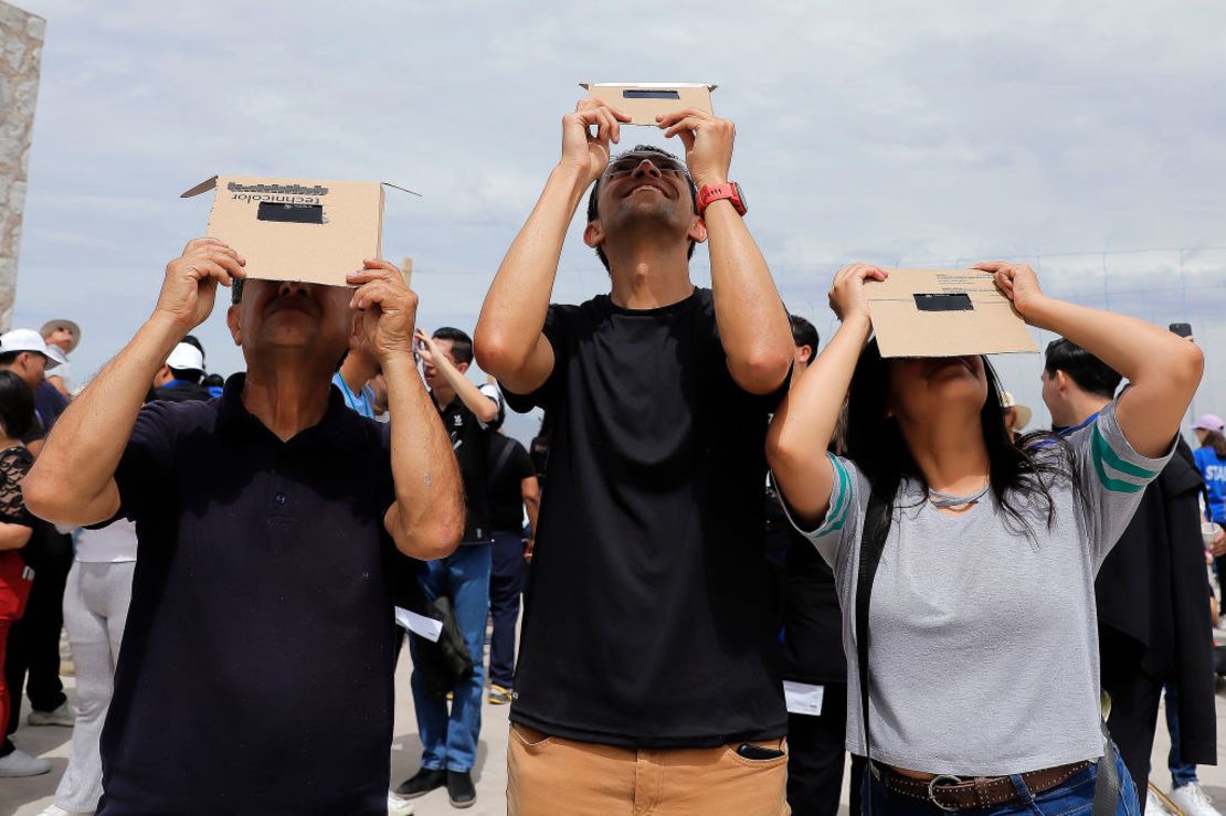 Personas observan el eclipse usando filtros para proteger la vista en el Cristo de Las Noas el 8 de abril de 2024 en Torreón, México.