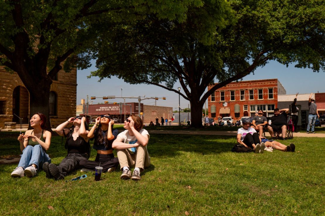 La gente observa el eclipse total en la transición de la luz del día a la oscuridad el 8 de abril de 2024 en Brady, Texas.