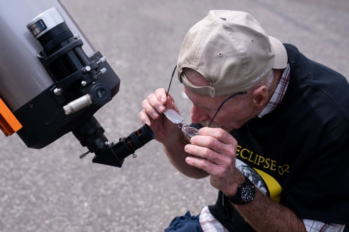 Un voluntario del Parque Nacional mira a través de un telescopio en la fiesta de observación del eclipse en el Área Recreativa Nacional Amistad en Del Río.