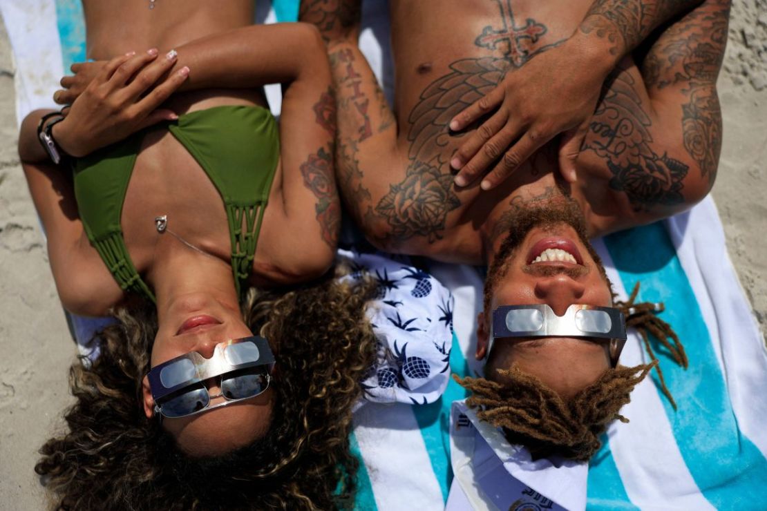 Laquishia Ferguson y su novio, Easy Ash, observan el eclipse desde la playa de Jacksonville, en Florida. "Estoy asombrada", dijo Ferguson.