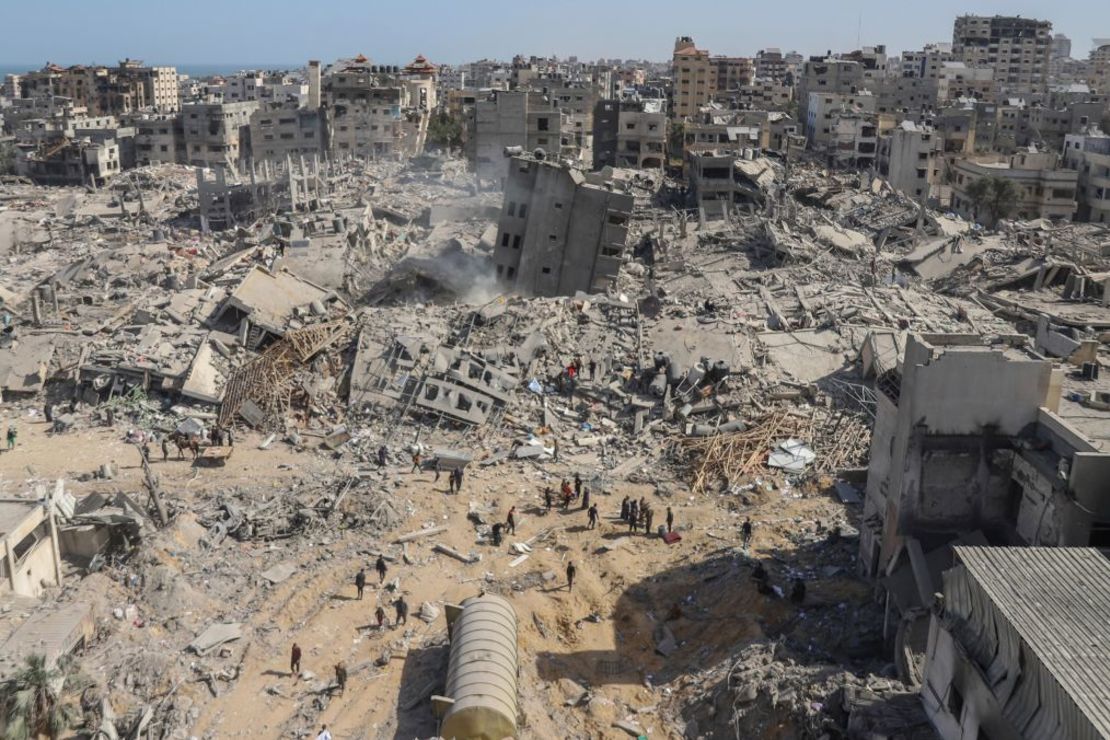 Palestinos caminan por la destrucción del Hospital Al-Shifa, en el norte de Gaza, el 1 de abril. Trabajadores sanitarios de Gaza dijeron a CNN que habían exhumado los primeros cadáveres de las fosas comunes excavadas por las fuerzas israelíes. Crédito: Mohammed Hajjar/AP