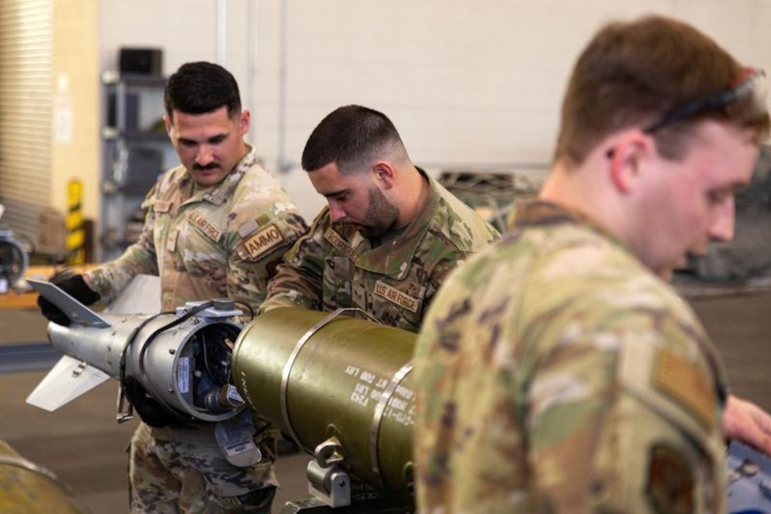 El aviador Avery Bulsterbaum (izquierda), el aviador Andrew Rodríguez (centro) y el aviador Justin Joyner (derecha) practican el montaje de bombas de precisión de 500 libras como parte de los equipos de municiones.