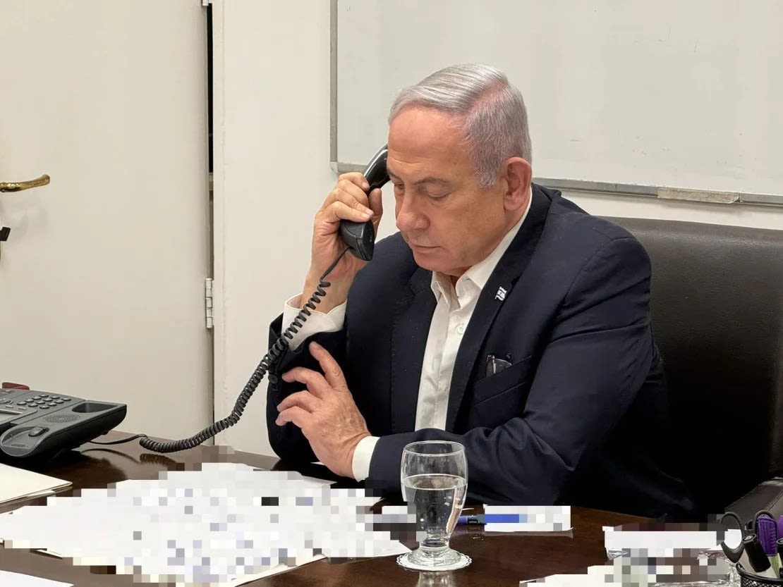 En esta foto, difundida a primera hora local este domingo, el primer ministro de Israel, Benjamin Netanyahu, habla por teléfono con el presidente de Estados Unidos, Joe Biden. Partes de esta foto fueron difuminadas por la fuente.