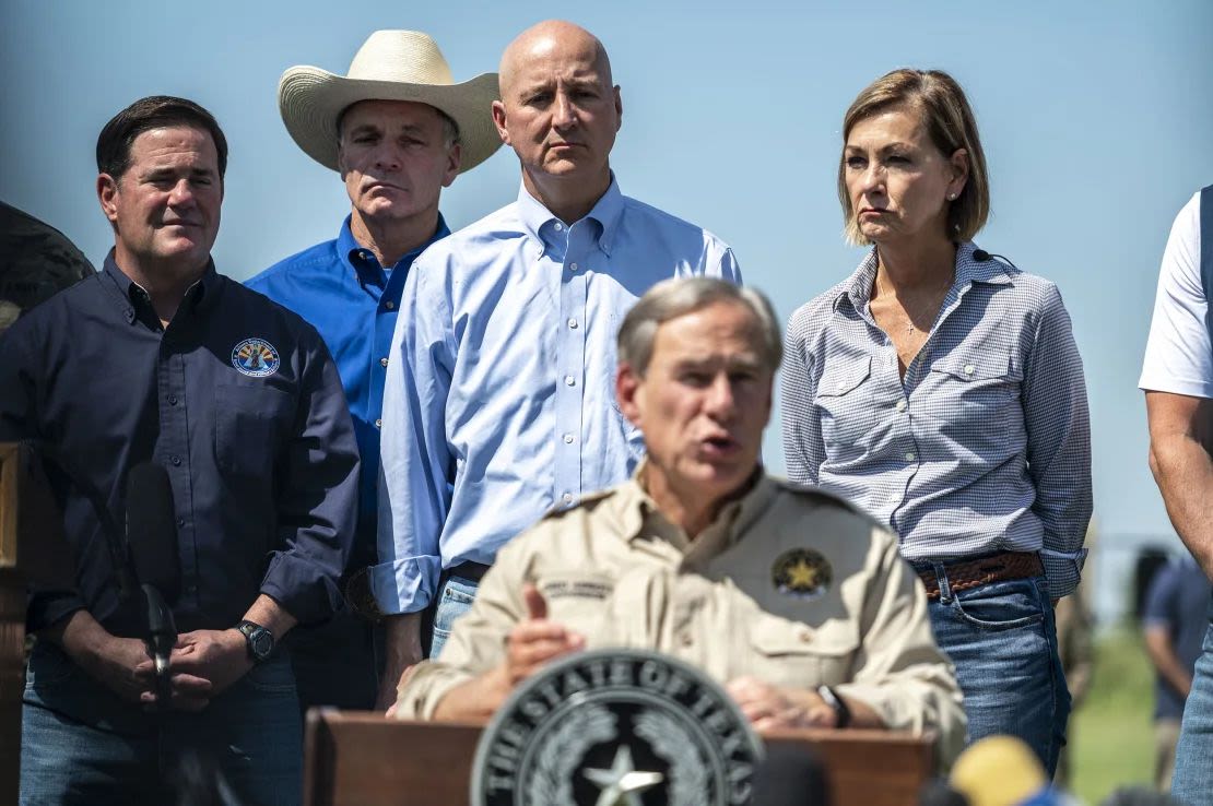 La gobernadora de Iowa, Kim Reynolds, a la derecha, junto a un grupo de gobernadores detrás del gobernador de Texas, Greg Abbott, durante una conferencia de prensa en la ciudad fronteriza de Mission, Texas, en octubre de 2021. Sergio Flores/Bloomberg/Getty Images.