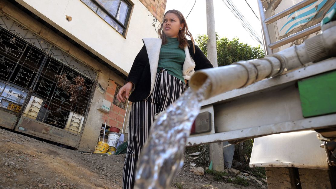 Una mujer recoge agua potable de un camión cisterna en La Calera, cerca de Bogotá, el 10 de abril de 2024.Crédito: DANIEL MUNOZ/AFP vía Getty Images