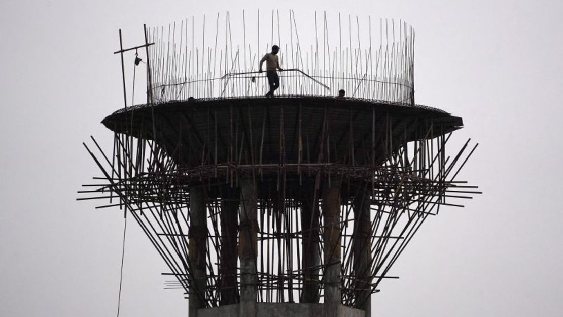 Un trabajador de la construcción transporta varillas de metal durante la construcción de un tanque de agua elevado en Ajmer, Rajasthan, el 30 de enero de 2024.