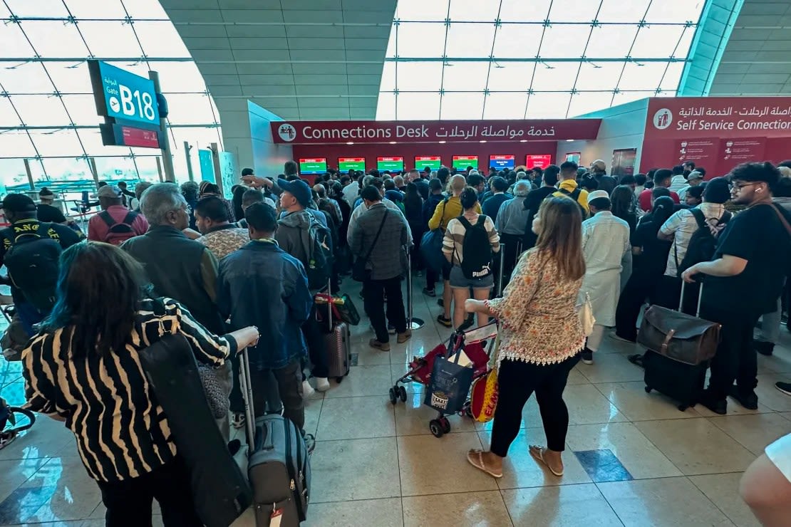 Pasajeros hacen fila en un mostrador de conexión de vuelos en el Aeropuerto Internacional de Dubai este miércoles.