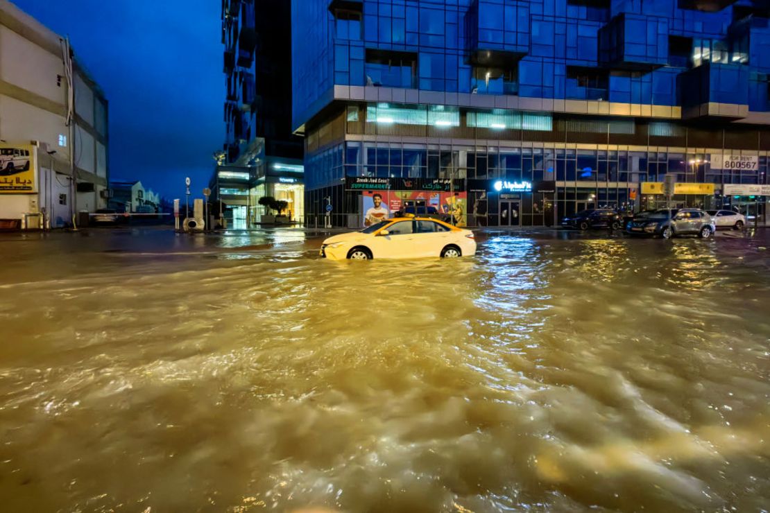 Un taxi circula por una calle inundada tras las fuertes lluvias en Dubai la madrugada del 17 de abril de 2024.