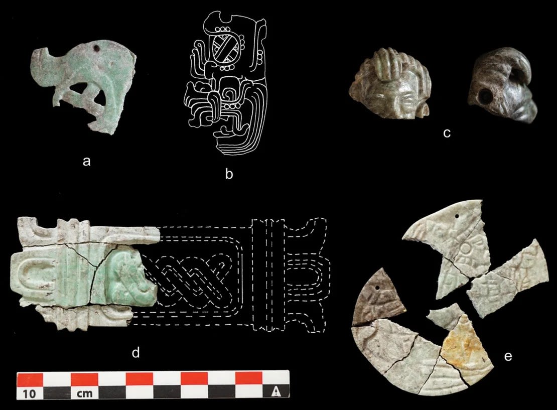 Del depósito funerario se rescataron adornos de piedra verde quemados y agrietados: a) una diadema de Hu'unal, b) un dibujo de una diadema de Hu'unal del sitio de Topoxté, c) un colgante de una cabeza humana, d) una placa con diseño de tapete (dibujo de D. Hounzell), y e) un disco decorado con un grabado. Crédito: C. Halperin/Cortesía de Antiquity.