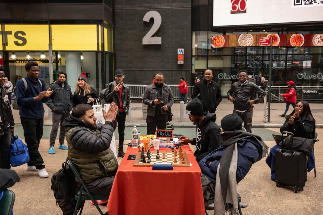 La gente celebra cuando Tunde Onakoya cumple 46 horas consecutivas jugando una partida de ajedrez en Times Square, el viernes 19 de abril de 2024, en Nueva York. Yuki Iwamura/AP