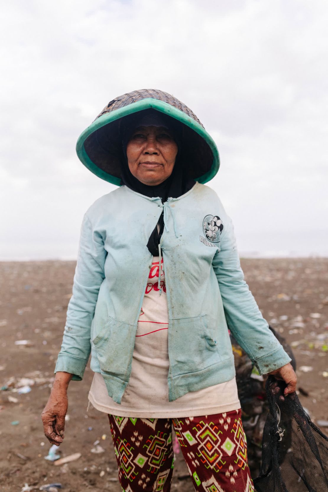 Marsinah recoge plástico en la playa de Loji para intentar venderlo a centros informales de reciclaje.