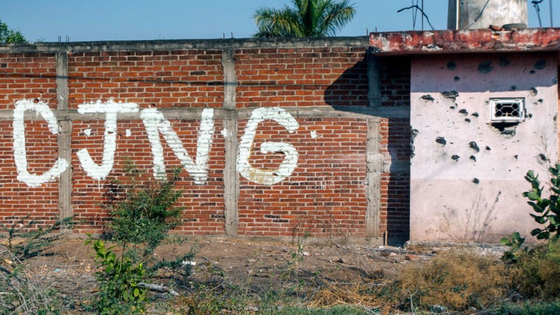 Vista de un muro acribillado a balazos con las iniciales del grupo criminal Cartel Jalisco Nueva Generación (CJNG) en la entrada de la comunidad de Aguililla, Michoacán, México, el 23 de abril de 2021.