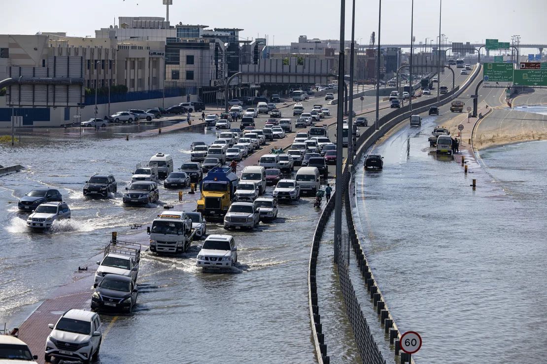 Varios vehículos atraviesan el agua de las inundaciones causadas por las fuertes lluvias del jueves en Dubai.