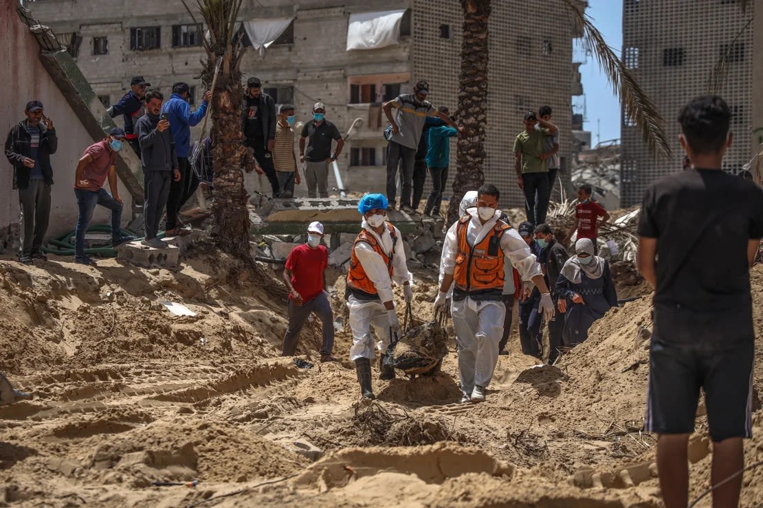 Personas y trabajadores sanitarios desentierran cadáveres encontrados el martes en el Hospital Nasser de Khan Younis, en el sur de Gaza. (Foto: AFP/Getty Images).