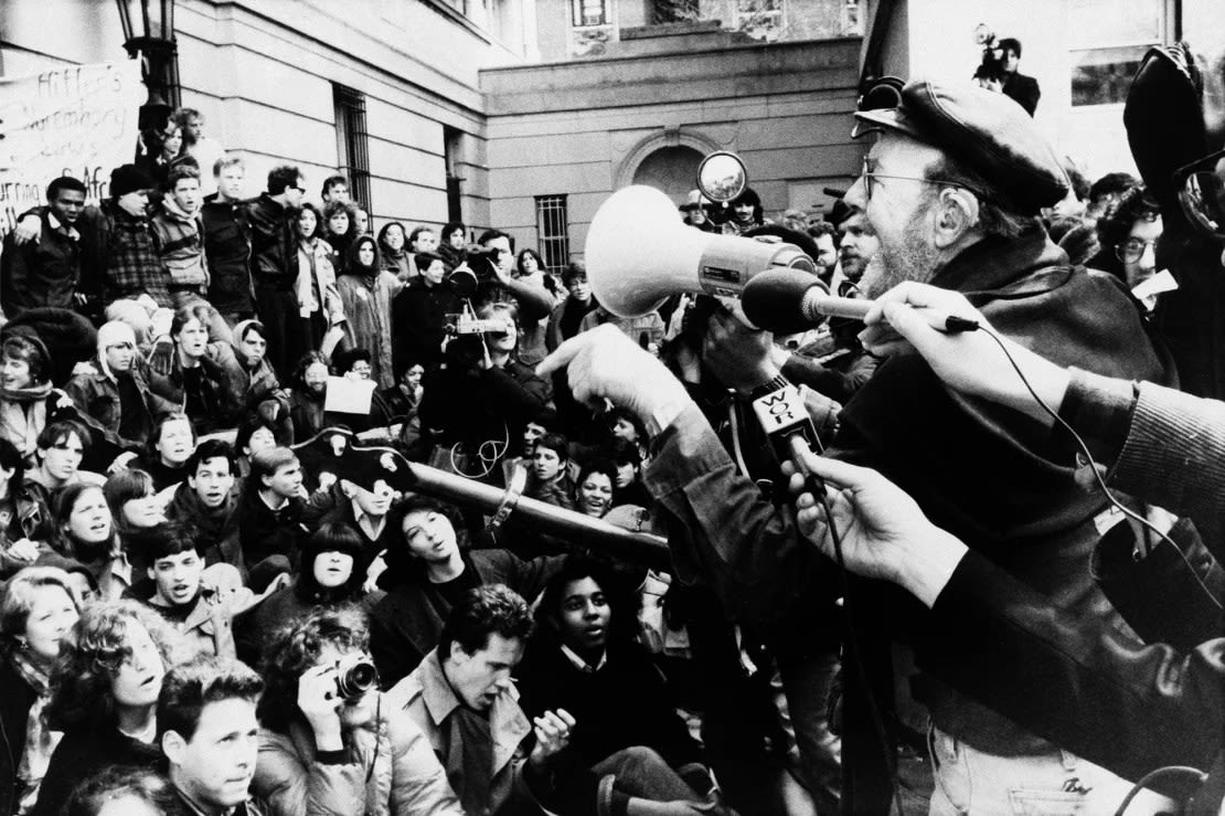 Pete Seeger, a la derecha, habla ante la multitud en la Universidad de Columbia mientras cientos de estudiantes continuaban protestando por los vínculos de la escuela con Sudáfrica, el 8 de abril de 1985. Las protestas fueron contra las inversiones de la universidad en Sudáfrica.