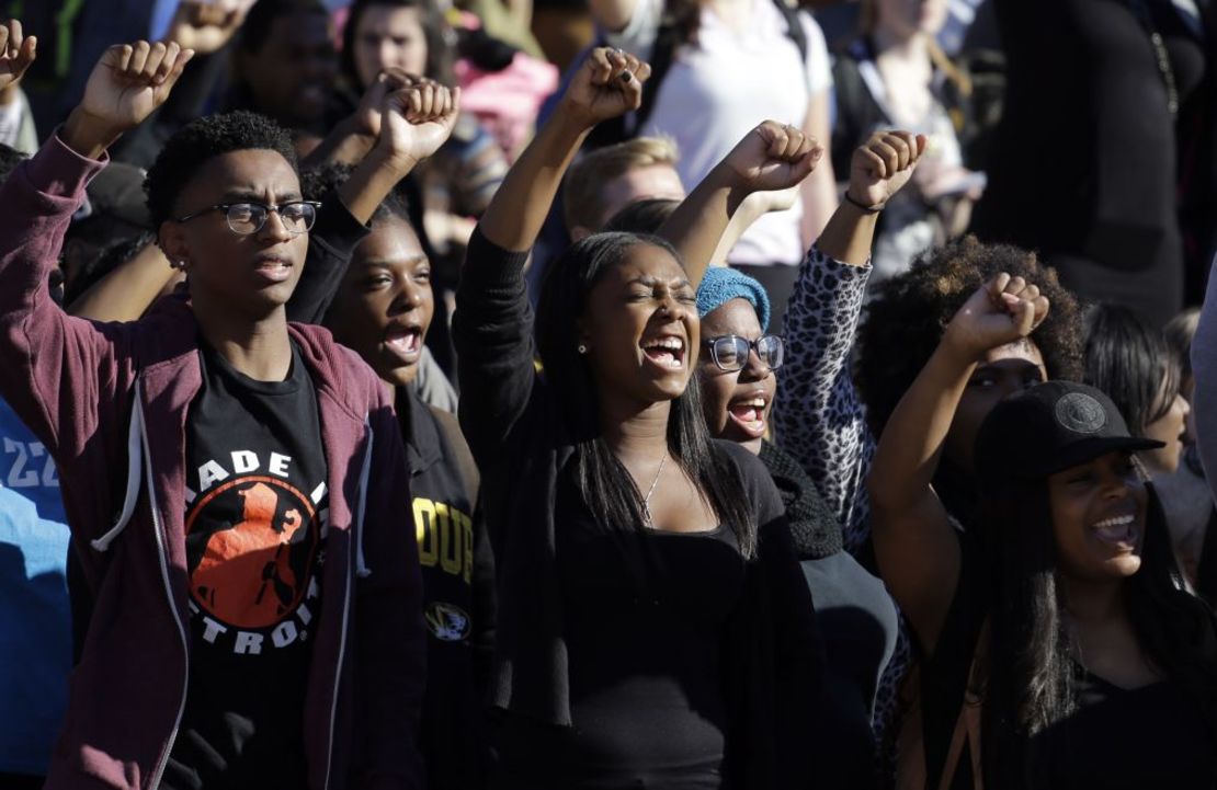 Estudiantes animan mientras escuchan hablar a miembros del grupo de protesta de estudiantes negros Concerned Student 1950, tras el anuncio de la dimisión del presidente del Sistema de la Universidad de Missouri, Tim Wolfe, el lunes 9 de noviembre de 2015. Crédito: Jeff Roberson/AP