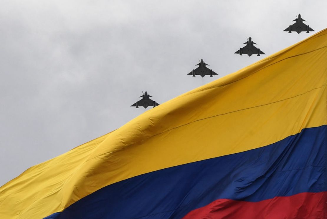 Aviones Kfir de la Fuerza Aérea Colombiana sobrevuelan una bandera colombiana durante una ceremonia conmemorativa del Día de la Independencia de Colombia en Bogotá el 20 de julio de 2021.