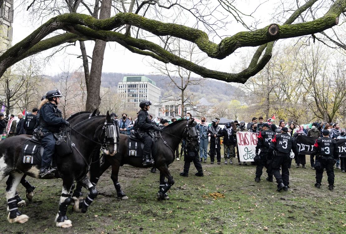 Agentes de la policía montada pasan junto a activistas propalestinos en un campamento instalado en el campus de la Universidad McGill en Montreal, el 2 de mayo.