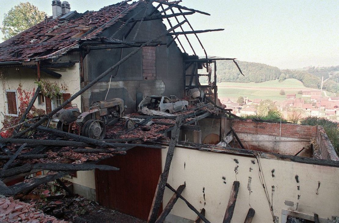 Fotografía tomada el 5 de octubre de 1994 que muestra la casa en llamas del pueblo de Cheiry, en el condado de Friburgo, en Suiza, donde se encontraron 23 cadáveres.