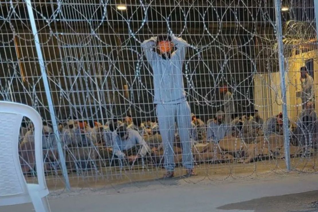 Una fotografía filtrada del centro de detención muestra a un hombre con los ojos vendados y los brazos por encima de la cabeza. Crédito: Obtenida por CNN