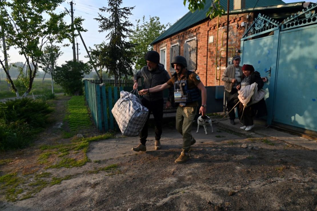 Voluntarios ucranianos ayudan a los residentes de los asentamientos en el norte de la región de Kharkiv durante su evacuación el 10 de mayo de 2024, en medio de la invasión rusa en Ucrania.