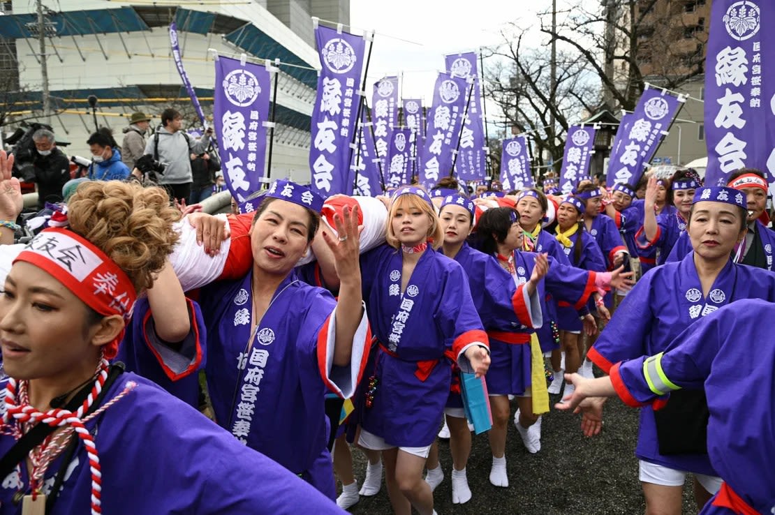 Mujeres ataviadas con happi, un abrigo festivo tradicional, se encargan de llevar una ofrenda de bambú durante el festival del desnudo en el santuario de Konomiya el 22 de febrero de 2024.