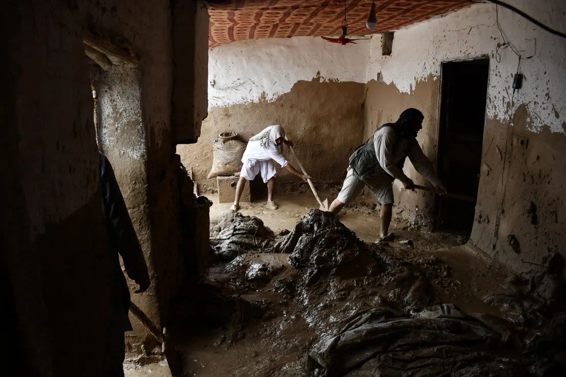 Hombres afganos sacan el barro de una casa tras las inundaciones.