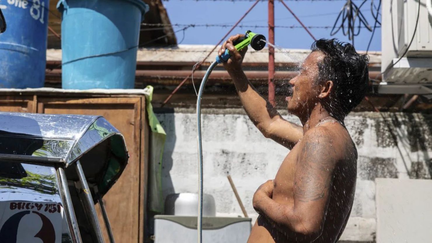 Un hombre se ducha con una manguera por el clima cálido en Manila, Filipinas, el 28 de abril de 2024. Crédito: Earvin Perias/AFP/Getty Images.