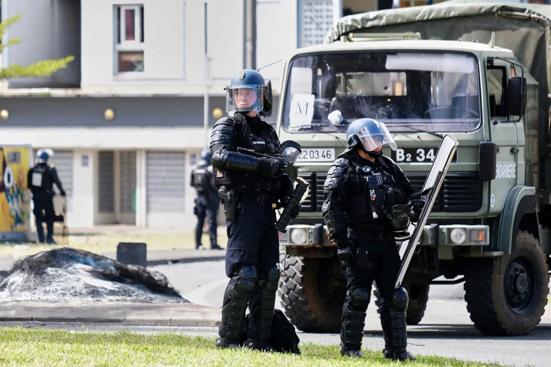 Oficiales de la gendarmería sa custodian la entrada del distrito de Vallee-du-Tir, en Noumea, Nueva Caledonia, el 14 de mayo de 2024.