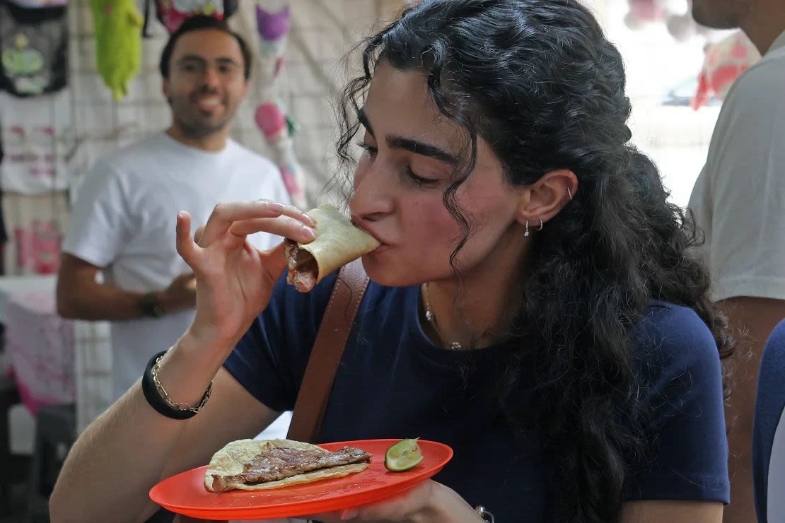 Una comensal disfruta de uno de los tacos populares en una atquería de la Ciudad de México.