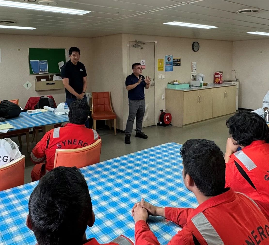 Bro Chen Chuanyi, secretario ejecutivo de la Organización de Marineros de Singapur, y Gwee Guo Duan, secretario general adjunto del Sindicato de Oficiales Marítimos de Singapur, hablan con marineros a bordo del Dali el 24 de abril, cuatro semanas después de que el carguero chocara contra el puente Key de Balitmore.