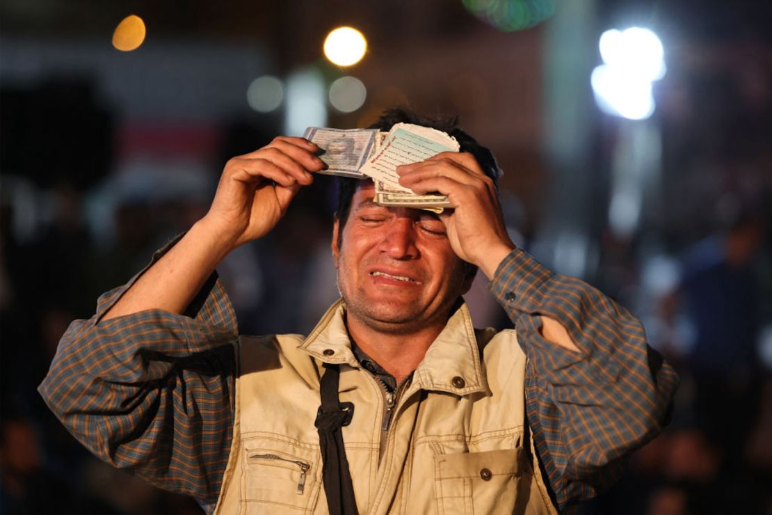 Un hombre iraní reza por el presidente Ebrahim Raisi y el ministro de Exteriores Hossein Amir-Abdollahian en la plaza Valiasr, en el centro de Teherán, el 19 de mayo de 2024.