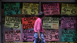 Un hombre observa los precios de los alimentos exhibidos en la fachada de un supermercado en Caracas el 8 de mayo de 2024.