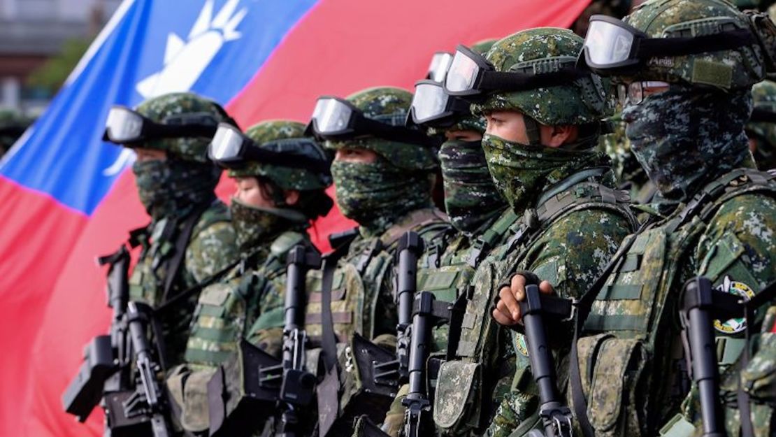 Soldados posan para fotos de grupo con una bandera de Taiwán después de un simulacro de mejora de la preparación que simula la defensa contra las intrusiones militares de Beijing en la ciudad de Kaohsiung, Taiwán, el 11 de enero de 2023.