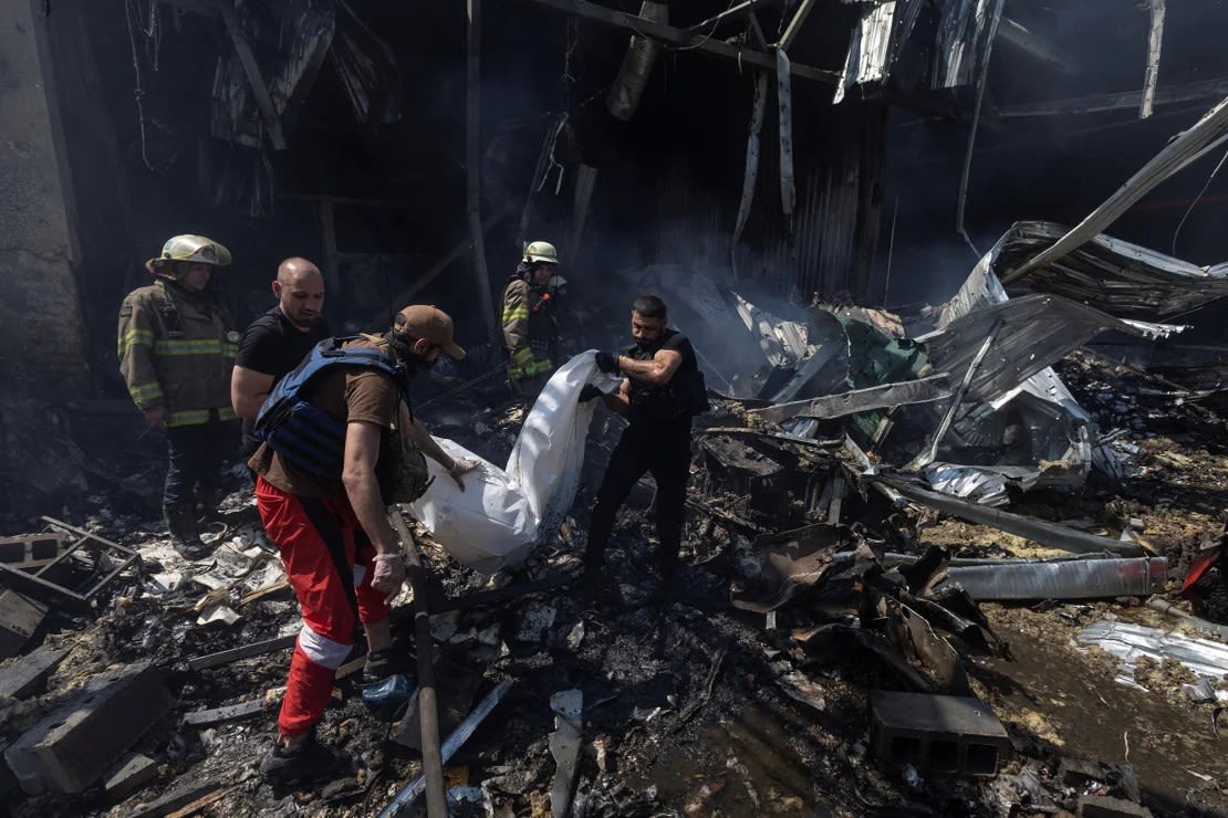 Voluntarios cargan el cuerpo de una persona muerta por ataques rusos en una imprenta en Járkiv, este jueves. Crédito: Valentyn Ogirenko/Reuters.