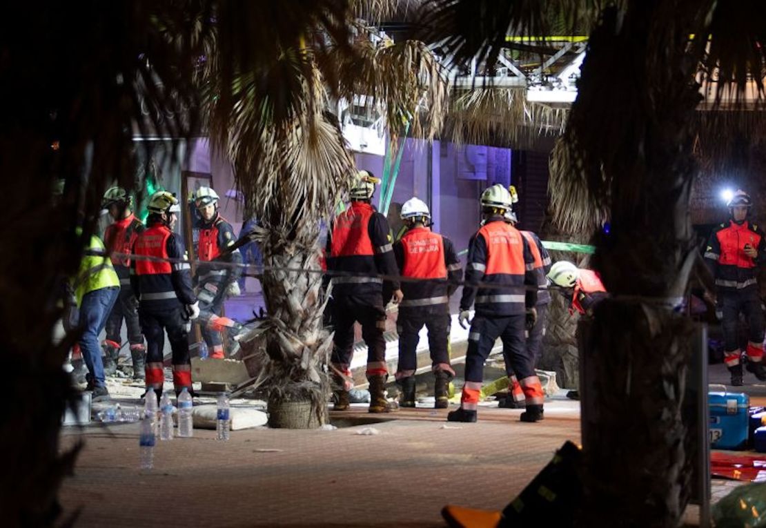 Miembros de los servicios de emergencia trabajan en el lugar tras el derrumbe del restaurante de dos plantas.