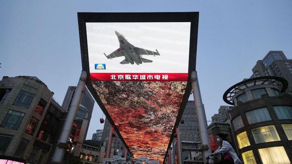 Una gran pantalla en Beijing muestra un avión de combate chino que participa en los simulacros militares de dos días de China alrededor de Taiwán el 23 de mayo de 2020.