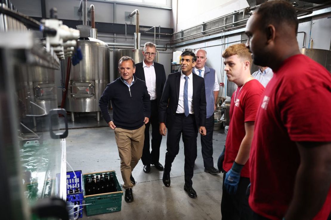 Sunak (centro) muestra una máquina embotelladora durante una visita de campaña a la fábrica de cerveza Vale of Glamorgan en Barry, al sur de Gales, el jueves. Crédito: Henry Nicholls/AFP/Getty Images