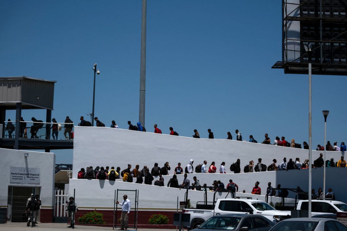 Solicitantes de asilo caminan hacia su cita para la entrevista con las autoridades estadounidenses en el puerto fronterizo de El Chaparral en Tijuana, estado de Baja California, México, el 18 de mayo de 2024.