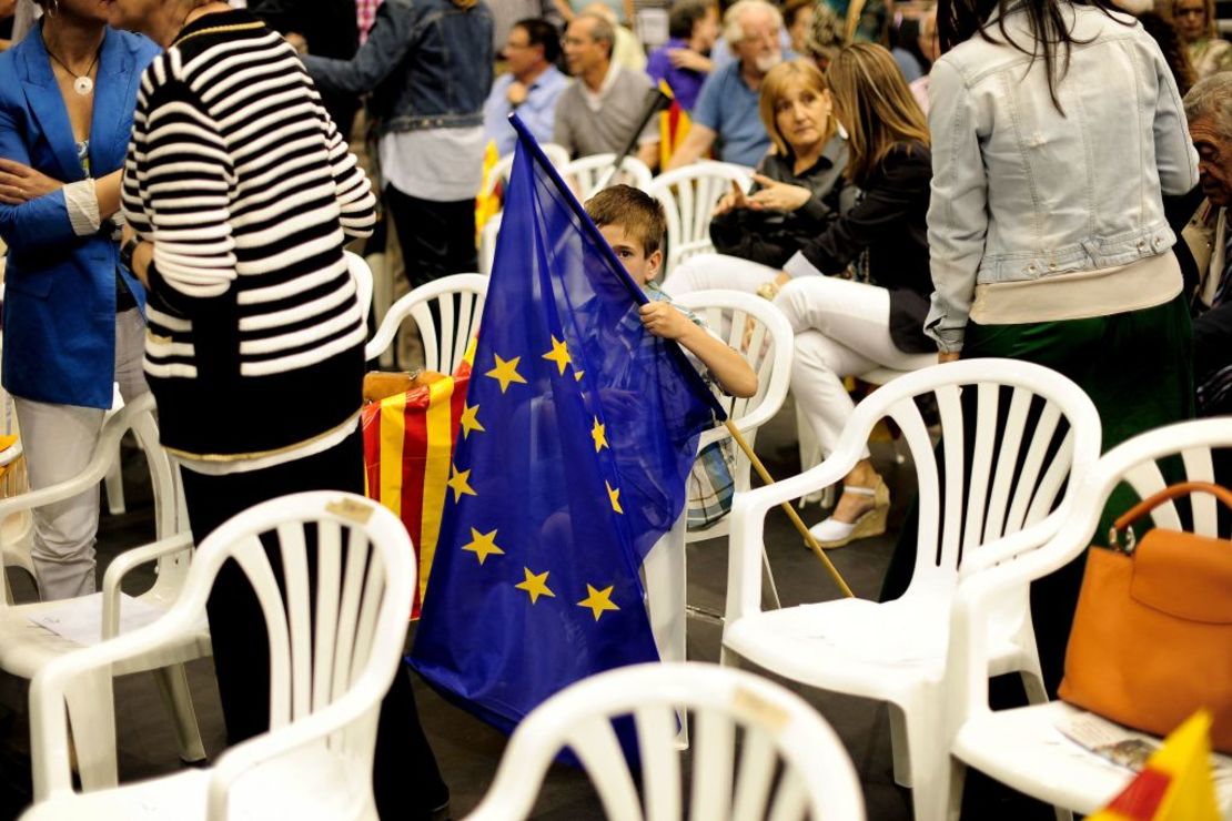 Un niño con una bandera europea espera el inicio del mitin del partido catalán Convergencia y Unidad (CiU) el 23 de mayo de 2014.