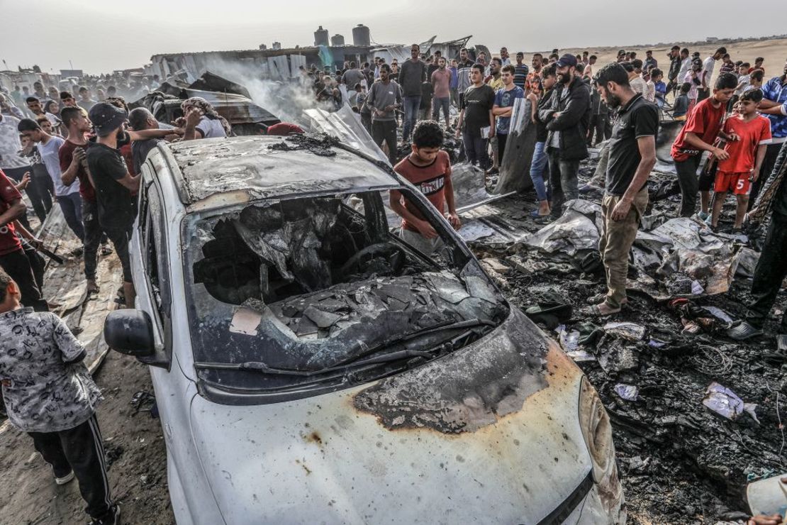 Los palestinos se reúnen alrededor de un coche quemado después de un ataque aéreo israelí sobre un campamento en la ciudad más meridional de Rafah, Gaza el lunes. Crédito: Abed Rahim Khatib/picture alliance/Getty Images