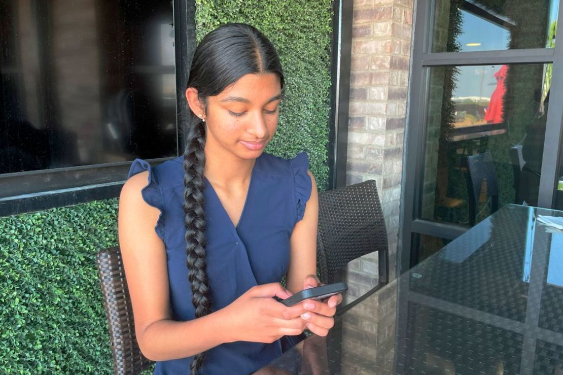 Shreya Nallamothu mira su teléfono en mayo de 2023 en Bloomington, Illinois. La adolescente fue decisiva para convencer a los legisladores de Illinois de que aprobaran una ley que protege a los niños influyentes en las redes sociales. Crédito: Claire Savage/AP