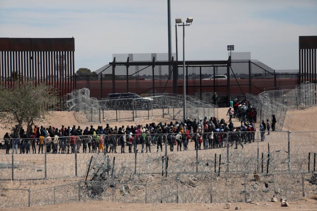 Migrantes hacen fila para ser trasladados por la Patrulla Fronteriza de Estados Unidos después de haber cruzado el río Bravo en El Paso, Texas, visto desde Ciudad Juárez, estado de Chihuahua, México, el 18 de abril de 2024. Crédito: Herika Martínez/AFP/Getty Images